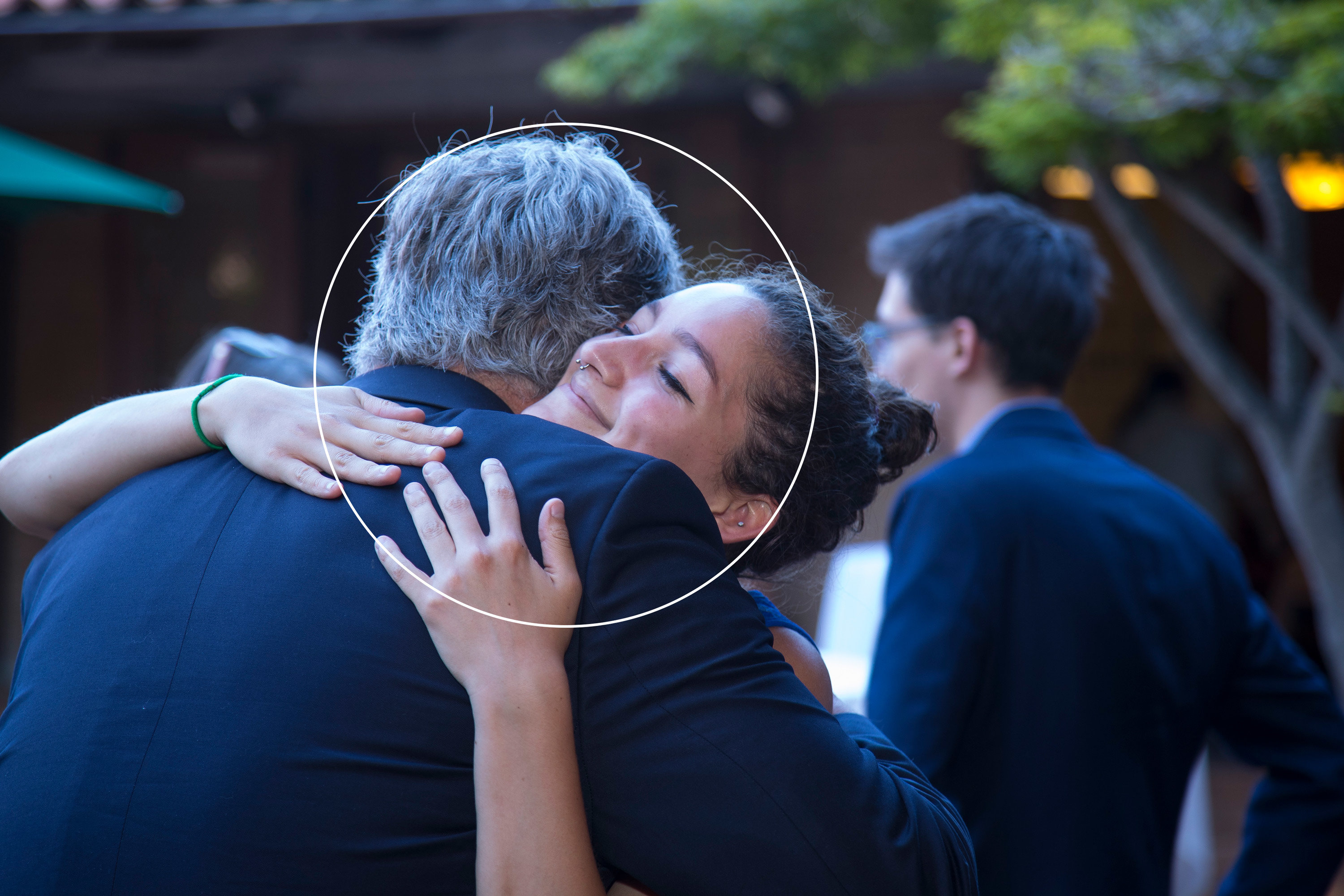 Two alumni embrace in a hug at an event