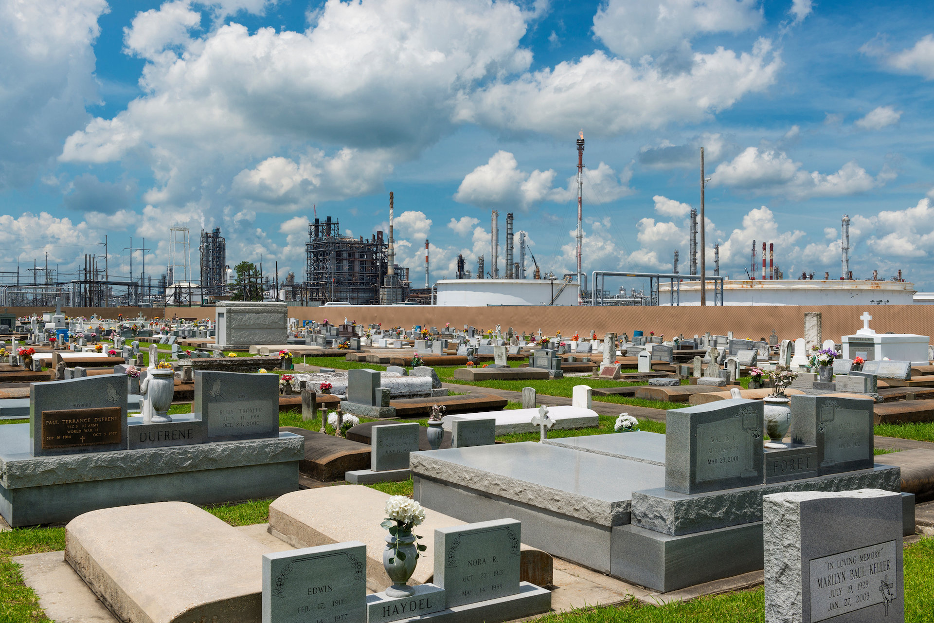 Taft, Louisiana - June 20, 2014: View of the Holy Rosary Cemetery in Taft, Louisiana, with a petrochemical plant on the background. The cemetery is located in Taft, in the so called 'Cancer Alley'.