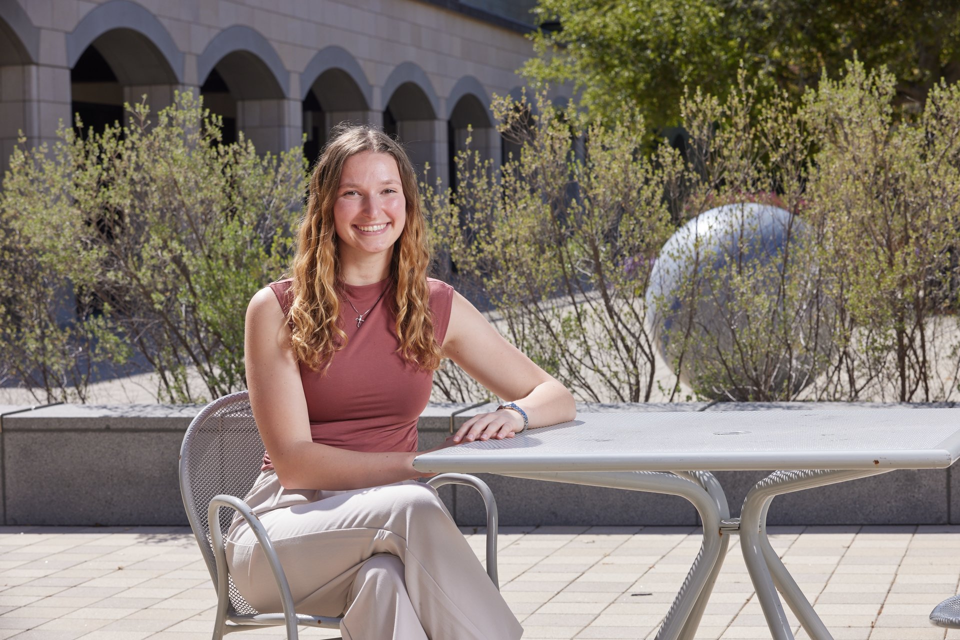 Emily Blackwell smiling at a table outside in the Science and Engineering Quad
