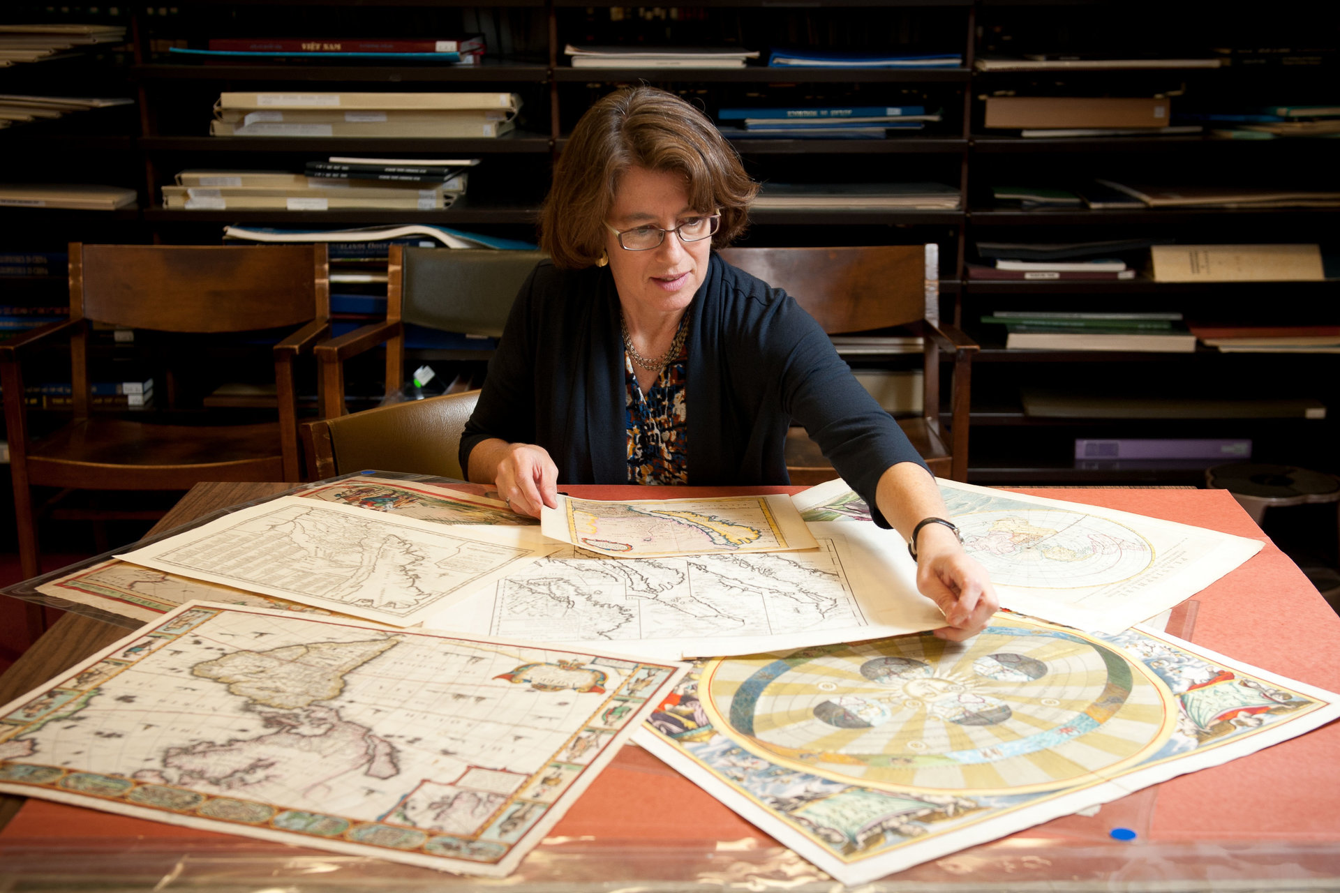 Chief librarian Julie Sweetkind-Singer at table viewing maps