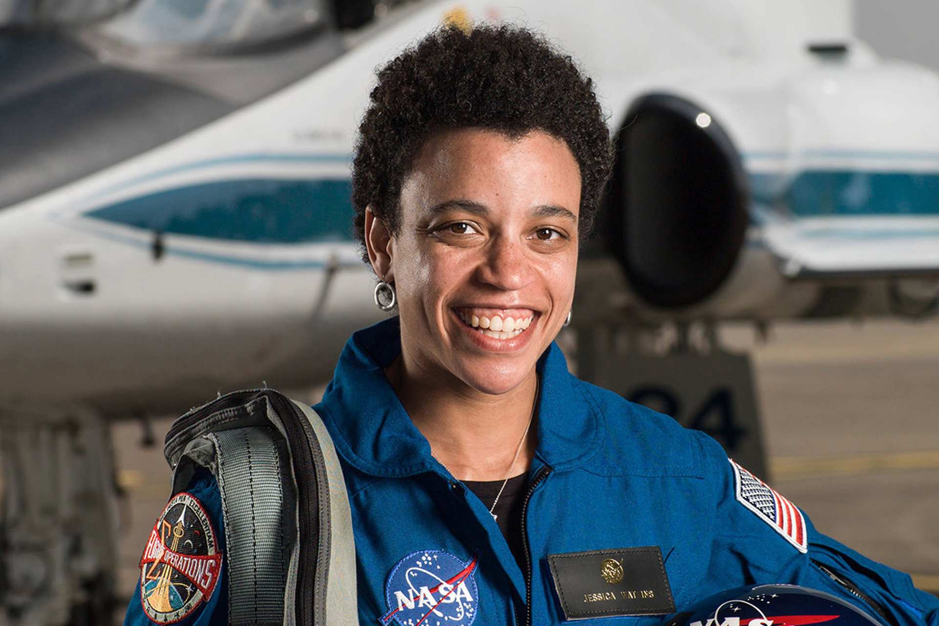 Jessica Watkins in her NASA uniform in a plane hangar
